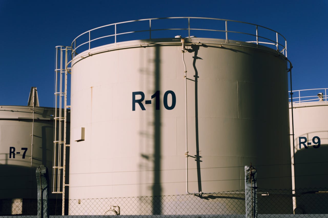 experience-img Large industrial storage tanks under blue skies, highlighting metal structures.